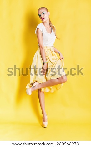 sexy woman in yellow skirt on yellow background