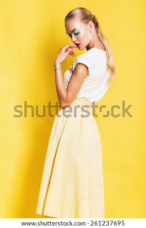 beautiful sexy woman in yellow skirt on yellow background