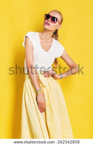 wet woman in sunglasses and yellow skirt on yellow background