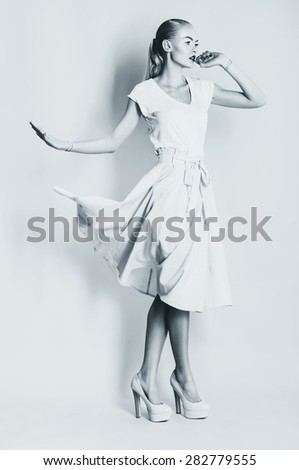 black and white dancing blond woman in skirt in studio