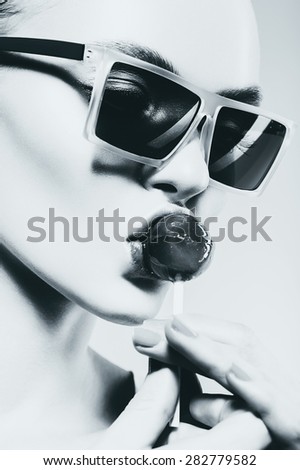 black and white sexy woman eating big lollipop in sunglasses