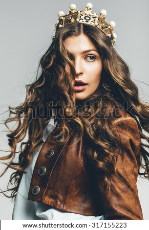 beautiful woman with flying hair in crown in studio