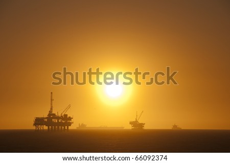 Oil rigs, ship and sunset in the ocean. Huntington Beach, California.
