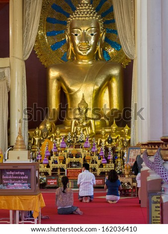 Chiang Mai, Thailand - October 25, 2013: Buddhist devotees praying in main temple at Wat Phra Singh in Chiang Mai, Thailand.