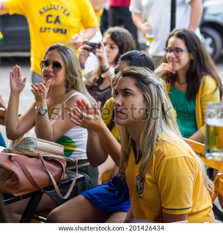 SALVADOR, BAHIA, BRAZIL - JUNE 28, 2014: Group of Brazilian girls watching World Cup football match on TV at a bar in Salvador, Bahia, Brazil, on June 28, 2014.
