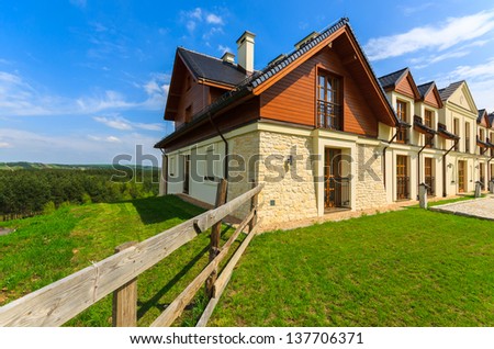 Traditional wood stone house building green lawn park, Bobolice Castle, Poland