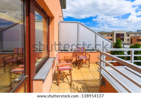 Terrace colorful chairs table luxury apartment white clouds sunny day, Krakow, Poland
