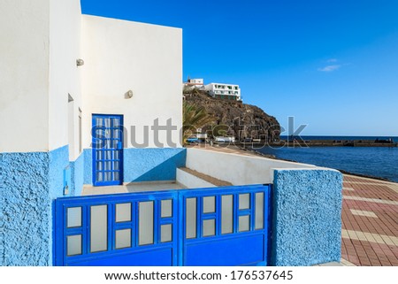 Blue gate and white house on promenade in fishing village Las Playitas on southern coast of Fuerteventura, Canary Islands, Spain