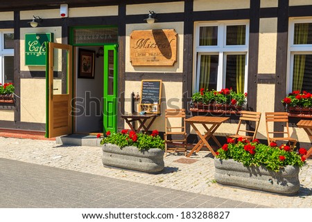 USTKA, POLAND - JUNE 12: traditional style restaurant in old cottage house decorated with flowers in Ustka town on 12th June 2013. This is typical architecture for this seaside resort town.