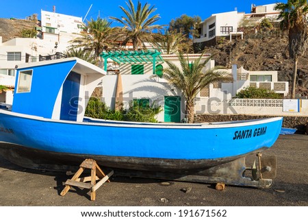 LAS PLAYITAS, FUERTEVENTURA - FEB 7, 2014: Blue fishing boat on shore in Las Playitas village, Fuerteventura island, Spain. Many holiday makers visit this fishing village.