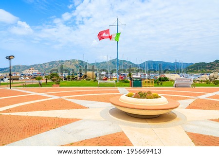 PORTO GIUNCO PORT, SARDINIA - MAY 25, 2014: Square with flower pot and Italian flag in Porto Giunco port. This popular place for tourists to rent boats and take trips around the island of Sardinia.