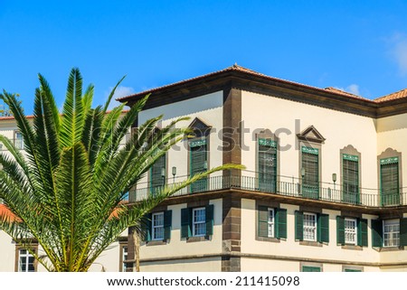 Palm tree and colonial architecture of palace in Funchal historic old town center on Madeira island, Portugal