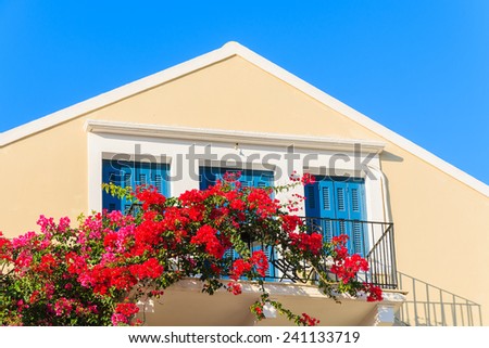 Red Bougainvillea flowers on balcony of typical Greek house in Fiskardo town, Kefalonia island, Greece