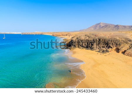 Couple of people in turquoise ocean water on Papagayo beach, Lanzarote, Canary Islands, Spain