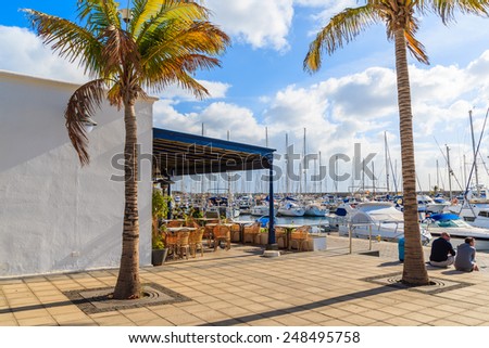 PUERTO CALERO MARINA, LANZAROTE ISLAND - JAN 17, 2015: restaurant building with palm trees in port built in Caribbean style in Puerto Calero. Canary Islands are popular sailing destination.