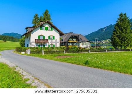 Typical houses along road in countryside landscape of Alps Mountains in summer landscape of Weissensee lake, Austria