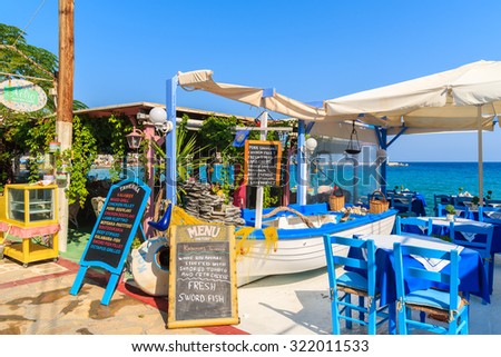 SAMOS ISLAND, GREECE - SEP 19, 2015: tables with chairs in traditional Greek tavern in Kokkari town on coast of Samos island, Greece.
