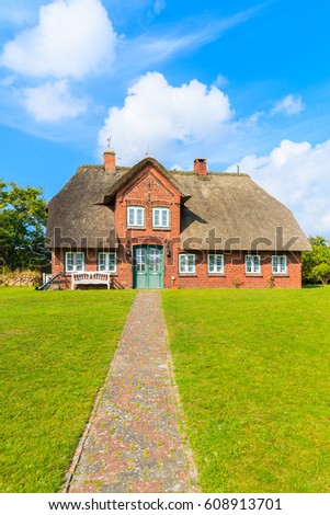 Foto Bild Rotes Backsteinfriesisches Haus mit Rosenhecke auf der Insel Sylt.