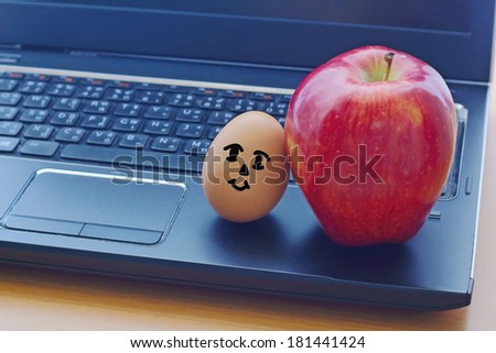 Red apple and egg dall on the notebook