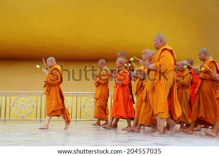 Ang Thong, Thailand-July 11,2014: Buddhists and monks walk with lighted candles clockwise round the temple, Asaha Puja Day and the beginning of Buddhist Lent, at Wat Muang- Ang Thong, Thailand.
