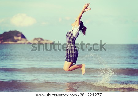 Jump to the freedom, Asian woman jumping on the beach, retro and vintage tone