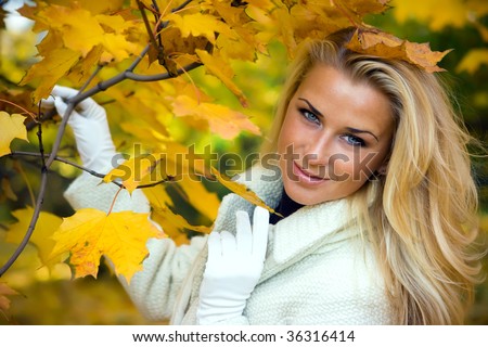Beautiful blonde girl in maple forest in autumn