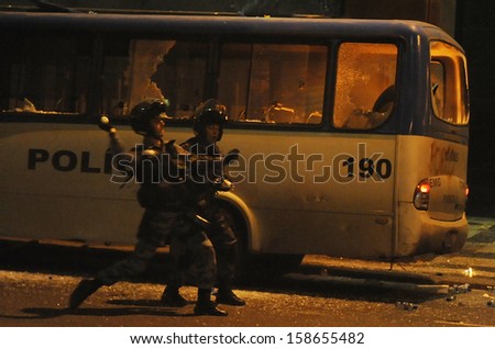RIO DE JANEIRO, BRAZIL - OCTOBER 15: Anti- riot police battalion officers launch a pepper gas bomb on an attempt to protect a police bus set on fire during protests in support to the teacher's strike as the annual October 15 Teachers' Day holiday came to