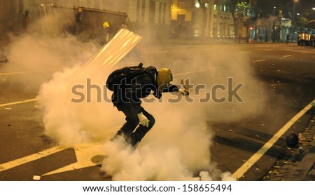 RIO DE JANEIRO, BRAZIL - OCTOBER 15: a protester is surrounded by tear gas on a barricade along the city center main avenue, Rio Branco, in support to the teacher\'s strike as the annual October 15 Teachers\' Day holiday came to a violent conclusion on Octo