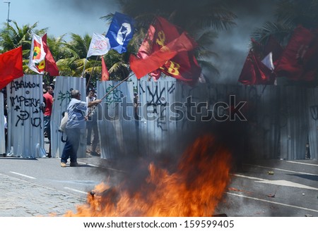 RIO DE JANEIRO, BRAZIL - 21 OCTOBER 2013: Oil workers demonstrators faces the National Force Security Battalion behind the barricades at the Barra da Tijuca beach.