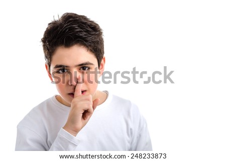 smooth-skinned Caucasian teenager in a white long sleeve t-shirt asks for silence touching his nose with  his right finger