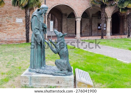 Saint Francis and the wolf statue in front of the XV century gothic roman church dedicated to Saint Francis in Cotignola near Ravenna in the countryside of Emilia Romagna in Italy.
