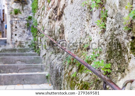 Ancient stone stairs with handrails in a street in the old town of a country village in countryside of Romagna