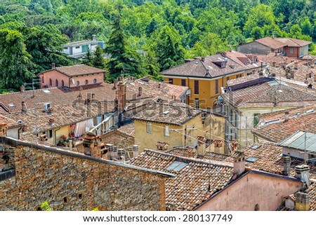 aerial view over red roofs and old houses facing each other in the old town of a country town in Italian countryside