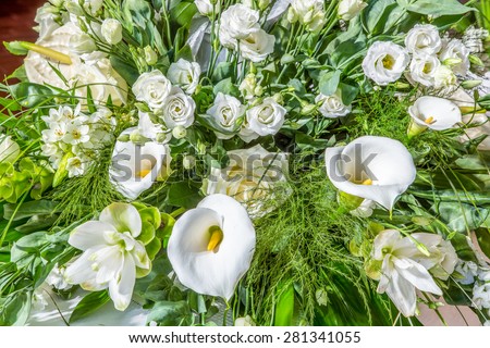 bouquet of white and yellow flowers, roses, calla lilies and green leaves