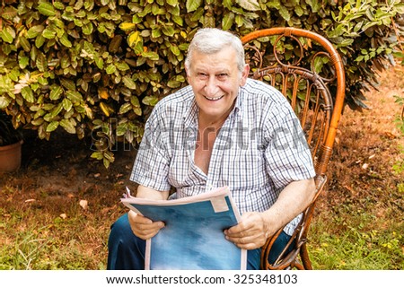 quiet retirement, old man reads the newspaper in the garden