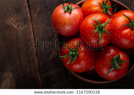 Fresh tomatoes in a plate on a dark background. Harvesting tomatoes. Top view Сток-фото © 