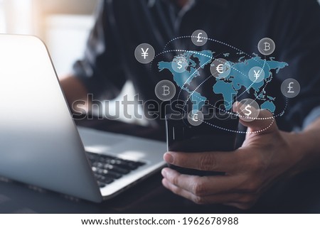 Currency exchange, money transfer, FinTech financial technology, Global business, online banking, interbank payment concept. Man using mobile phone and laptop computer with international currencies