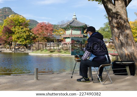 SEOUL, KOREA - OCTOBER 28: Unidentified Japanese  artist painting on canvas painting board on October 28, 2014 at Gyeongbokgung palace in Seoul, South Korea.