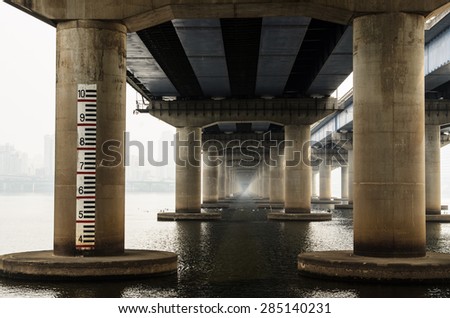 Under the old concrete bridge across Han river with scales on the post, Korea..