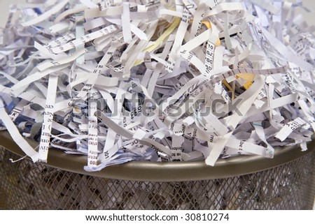 Closeup of shredded paper in a wastebasket.