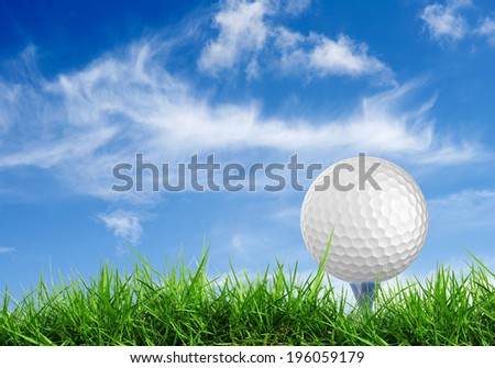 close up golf ball on tee with grass field blue sky background