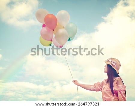 Vintage photo of  Happy Ethnicities Asian women  holding colorful balloons and flying on clouds sky background.