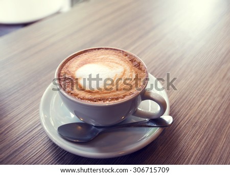 cup of coffee on table in cafe , vintage or retro color effect - shallow depth of field