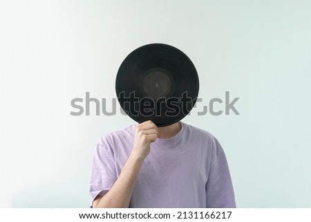 Similar – Image, Stock Photo Man holding vinyl record. Vintage music style. Rock style. Male wearing black jacket holding black disc standing on dark background. Retro music