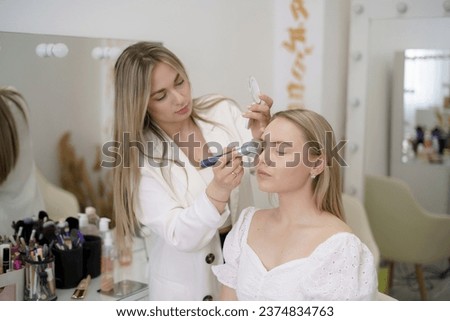 Similar – Image, Stock Photo Professional visagiste applying powder on model face