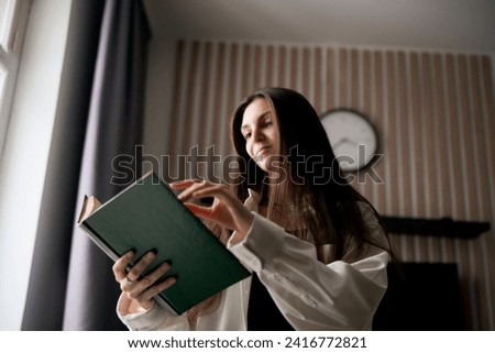 Similar – Image, Stock Photo Reading girl deeply absorbed in a book, stretching her feet from a colorful striped hammock
