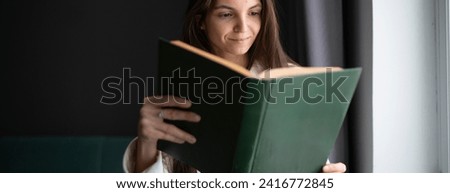 Similar – Image, Stock Photo Reading girl deeply absorbed in a book, stretching her feet from a colorful striped hammock