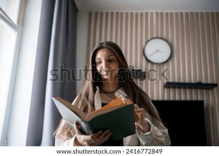 Similar – Image, Stock Photo Reading girl deeply absorbed in a book, stretching her feet from a colorful striped hammock