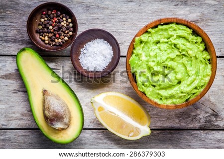 ingredients for homemade guacamole: avocado, lemon, salt and pepper top view