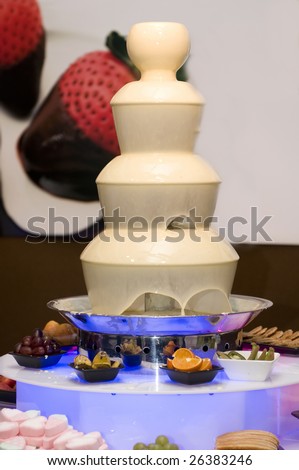 Source(Fountain) of white melted(enamored) chocolate and fruit